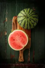 watermelon-sliced-on-wood-background.webp