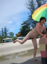 Small_umbrella_dance_at_the_beach.webp